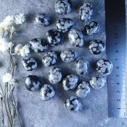 Black & White Snowflake Obsidian Tumbles - Embrace inner peace! Dumi's Crystals offers calming stones (1.5-2.5cm) with snowflake inclusions. Perfect for emotional balance and growth (5-10g or 10-15g). 