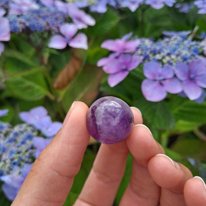 Dumi's Crystals | Chevron Amethyst Mini Spheres (20mm) | A collection of captivating Chevron Amethyst Mini Spheres, each displaying unique variations of purple and white chevrons. These 20mm spheres are believed to promote balance, clarity, spiritual growth, and protection. Perfect for meditation, crystal grids, or carrying with you throughout the day.