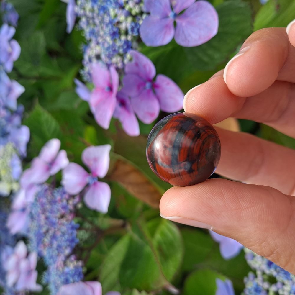 Dumi's Crystals | Bloodstone Mini Sphere (20mm) | A close-up view of a captivating Bloodstone Mini Sphere, showcasing its vibrant green hues speckled with red. This 20mm sphere ignites your inner fire, promoting strength, courage, and a renewed sense of vitality. It's also believed to foster emotional healing, balance, and a positive outlook on life.