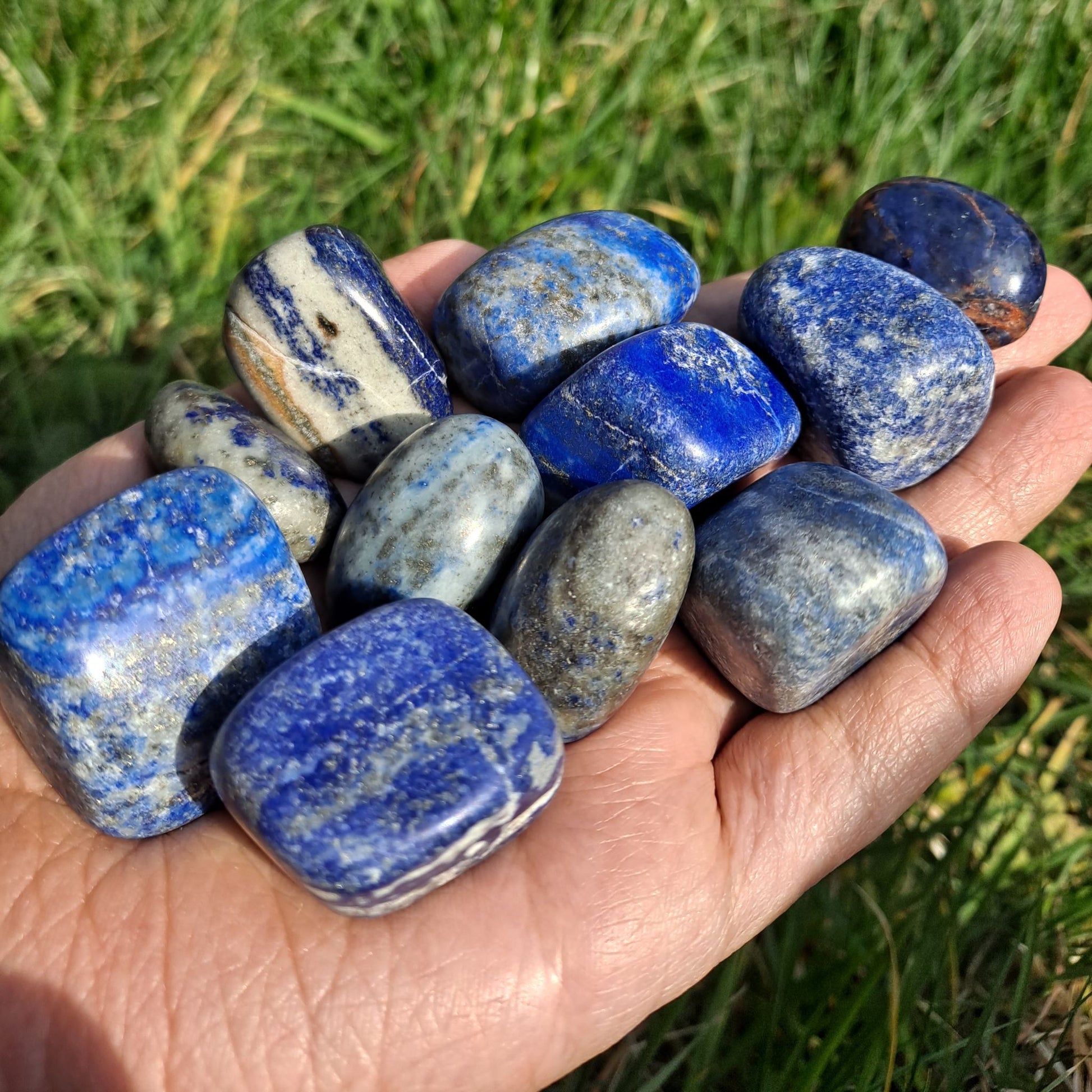 Dumi's Crystals | Lapis Lazuli Tumbled Stones (Wisdom & Truth) | A handful of Lapis Lazuli Tumbled Stones radiate deep blue hues with gold flecks. Renowned for promoting inner peace, self-expression & spiritual growth, hold them during meditation or carry them throughout the day to unlock your potential and speak your truth with confidence.