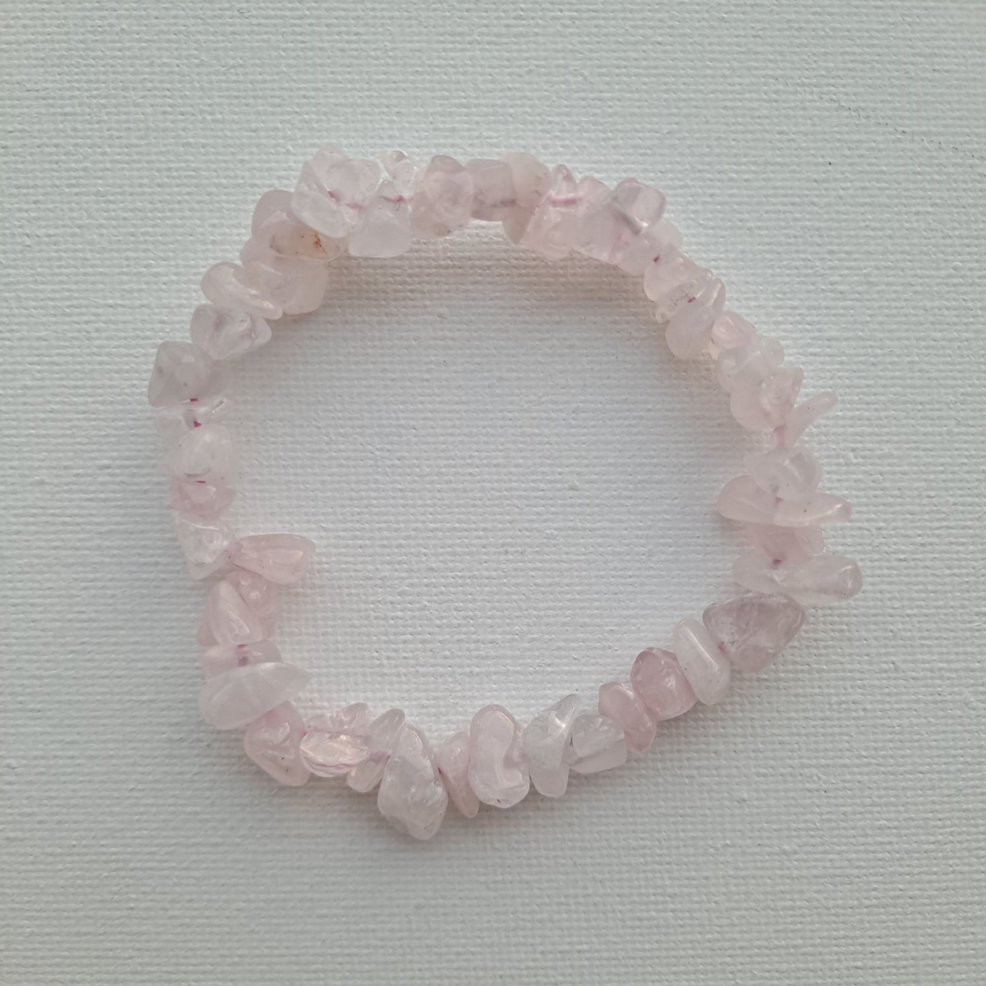 Dumi's Crystals | Rose Quartz Chip Stretch Bracelet (7 Inch) | Close-up of a handcrafted bracelet featuring genuine Rose Quartz chips in varying shades of pink. Rose Quartz is known as the stone of unconditional love and is believed to promote emotional healing and self-love.