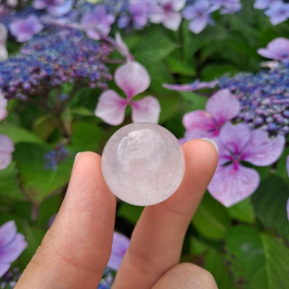 Dumi's Crystals | Rose Quartz Sphere (25mm) | A close-up view of a captivating Rose Quartz Sphere (25mm), showcasing its delicate pink hue and soft luster. This gemstone, known as the Stone of Unconditional Love, radiates pure heart-opening energy. It's believed to promote love, compassion, emotional healing, and self-acceptance.